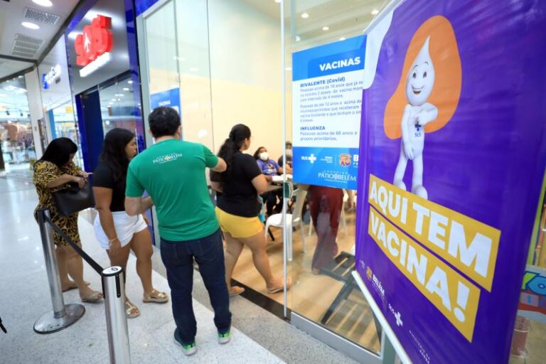 Multidão em fila para vacinação em Belém, refletindo a busca intensa por imunização contra COVID-19 e gripe.