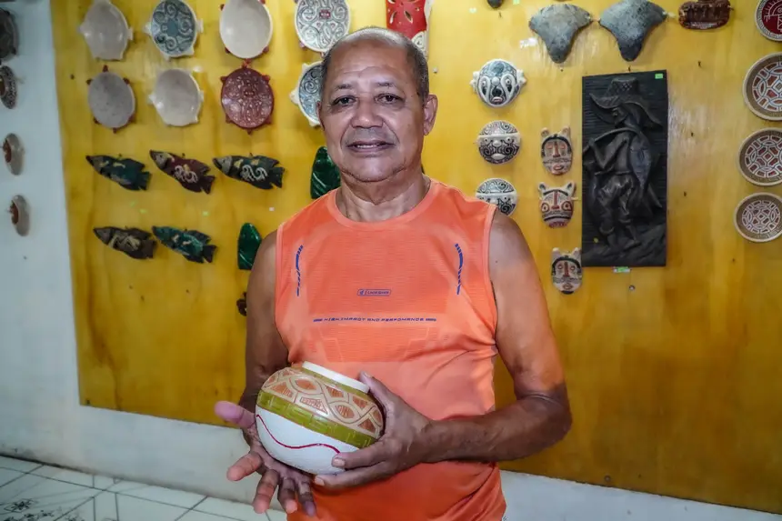 Mestre Doca Leite frente ao painel de visibilidade de seus produtos no Espaço São José Liberto (ESJL), em Belém