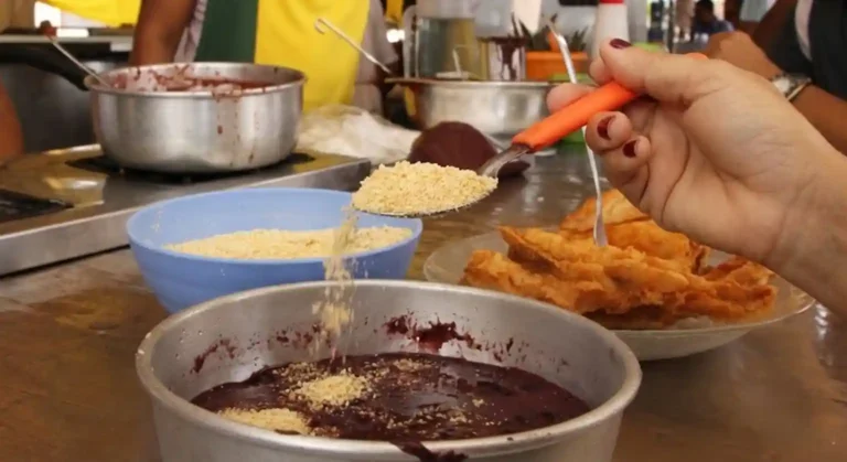 dourada ao lado de uma tigela de açaí roxo vibrante com farinha d'água no ver-o-peso
