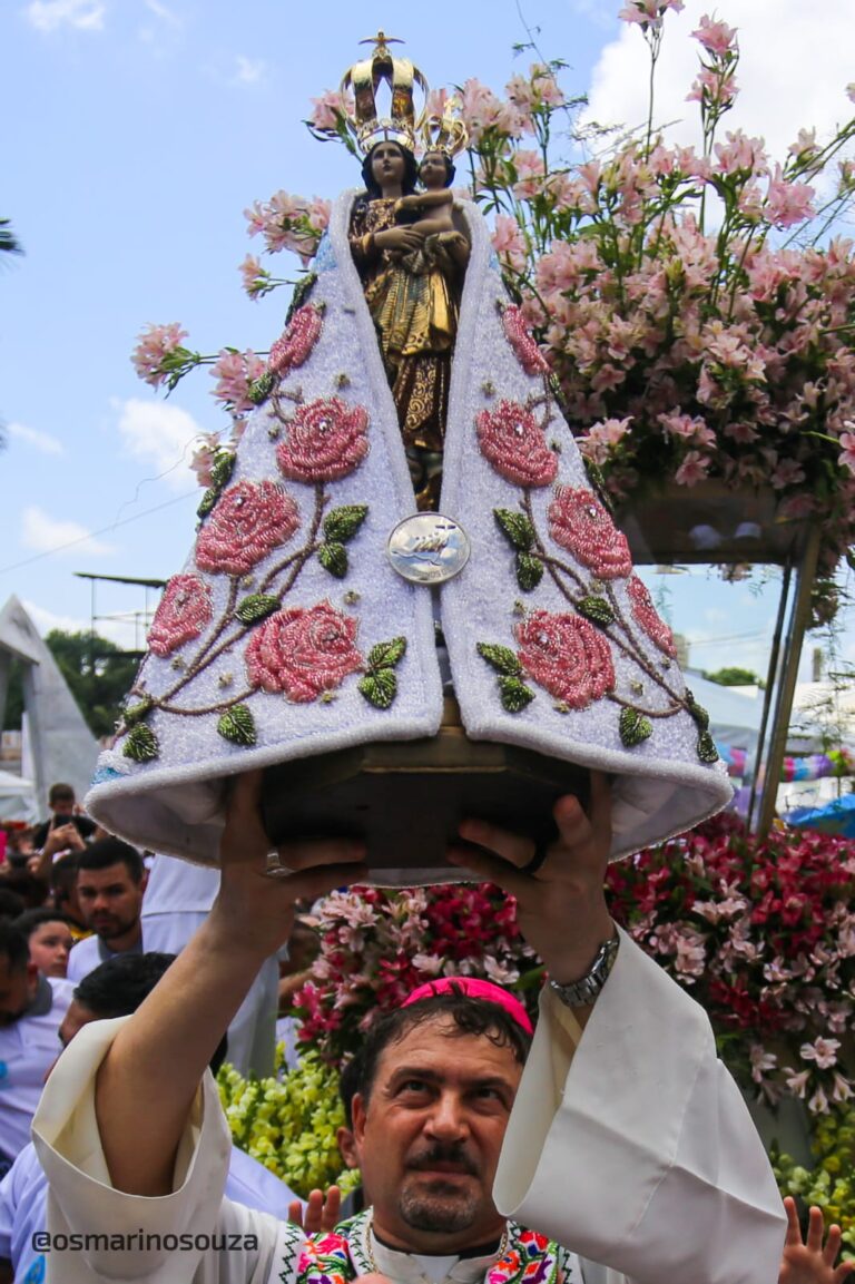 Bispo ergue a imagem de Nossa Senhora de Nazaré com manto bordado de rosas diante de fiéis e de um andor florido em Belém