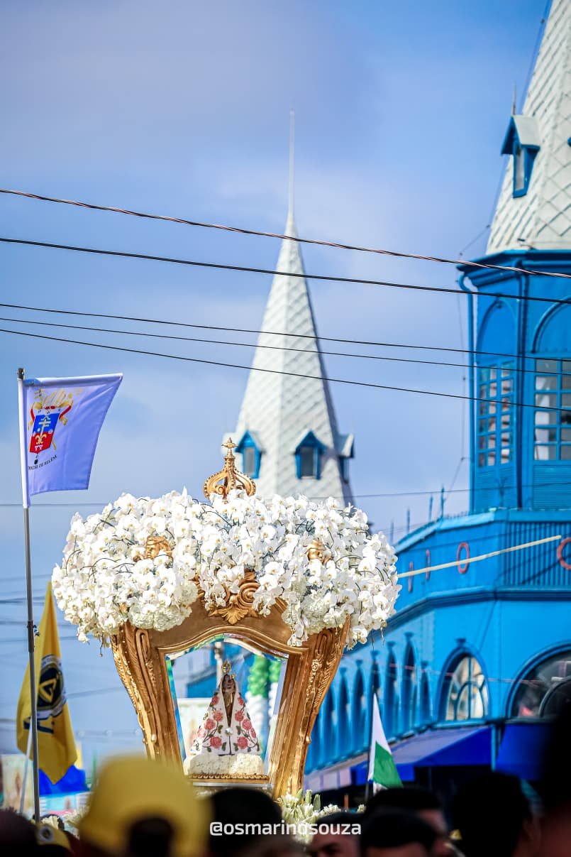 Berlinda com orquídeas brancas diante da torre de uma igreja em Belém