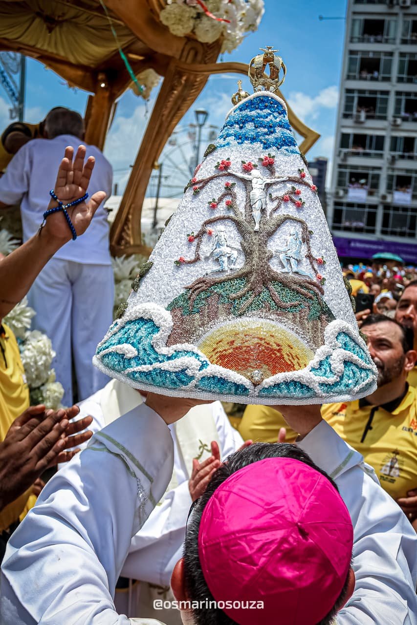 Manto branco com bordados em azul erguido por sacerdote