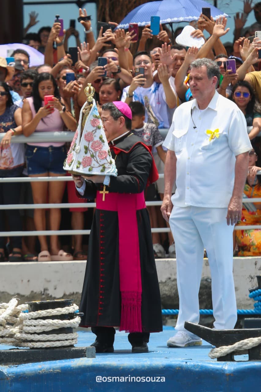 Religioso ergue a imagem de Nossa Senhora de Nazaré diante de uma multidão